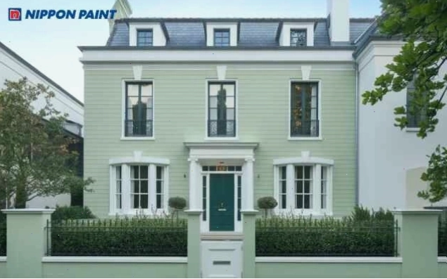 Nhà phố hiện đại sơn màu xanh lá cây với cửa kính và ban công trắng tinh tế